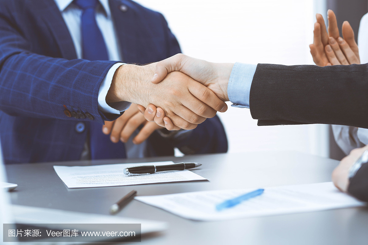商人們握手,完成一份文件簽名。會議、合同及律師咨詢理念